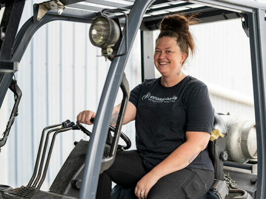 Female staff member driving forklift