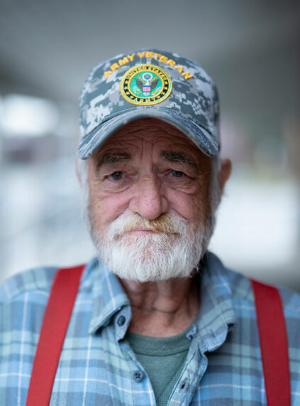 Male resident wearing United States Army Veteran hat outside Kokomo Rescue Mission men's shelter